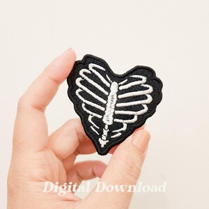 May include: Black and white embroidered iron-on patch in the shape of a heart with a ribcage design.