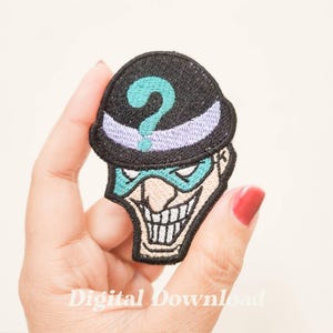 May include: An embroidered iron-on patch featuring the face of The Riddler from Batman. The patch is black, green, and purple with a question mark on the hat.