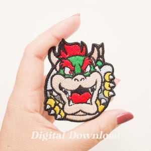 May include: Embroidered Bowser patch from the Super Mario video game series. The patch features Bowser's face with red, green, and yellow details. The text "Digital Download" is visible at the bottom.