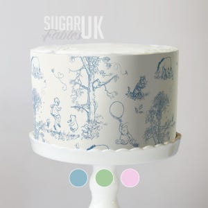 A cake decorated with a Winnie the Pooh theme, featuring illustrations of the characters and a tree.