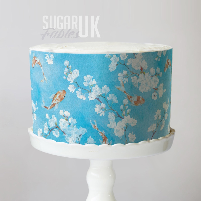 A cake with a blue and white floral pattern on its side, sitting on a white cake stand.