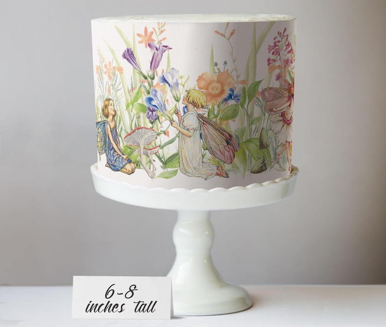 A cake stand with a decorative paper featuring illustrations of fairies and flowers on it.