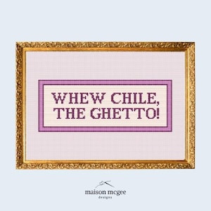 May include: A framed cross-stitch with the phrase "WHEW CHILE, THE GHETTO!" in purple. The text is on a light pink background, framed by a purple border. The frame is gold. The Maison McGee Designs logo is at the bottom of the image.