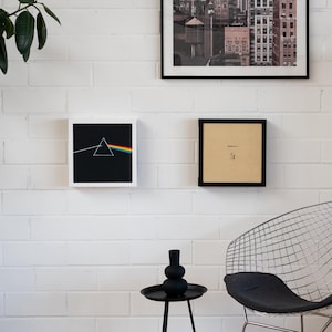 Pode incluir: Uma exposi&ccedil;&atilde;o de parede com arte e decora&ccedil;&atilde;o emolduradas. A obra de arte inclui uma impress&atilde;o de paisagem urbana em preto e branco, uma impress&atilde;o emoldurada em preto com texto e uma impress&atilde;o emoldurada com um fundo preto e um design de prisma de arco-&iacute;ris.