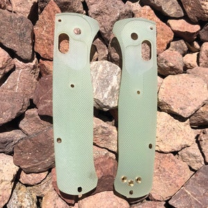 May include: Two translucent green knife scales with multiple holes and a textured surface.