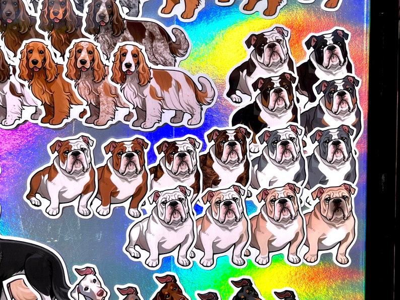 May include: A collection of colorful stickers featuring various dog breeds, including bulldogs and spaniels. The stickers are printed on a holographic background.