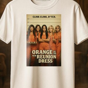 May include: White t-shirt featuring a graphic from the show "Orange is the New Black." The graphic includes the text "CLINK CLINK, B*TCH." and "ORANGE IS THE NEW REUNION DRESS." The image shows a group of women in orange jumpsuits.