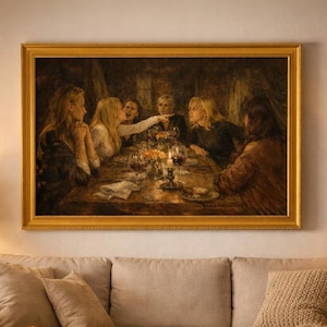 May include: A living room scene featuring a large framed painting depicting a group of people at a table. A beige sofa with throw pillows and a blanket sits below the painting. A round coffee table holds a candle, bowl, and mug. A lamp and side table are on the left.