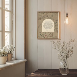 a serene indoor setting with a framed quote on the wall, a vase of flowers on a windowsill, and a light fixture hanging from the ceiling.