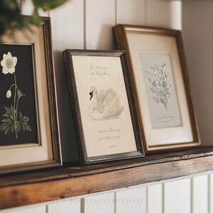 a couple of framed pictures sitting on top of a mantle