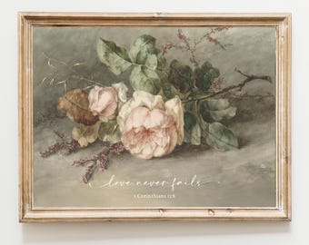 May include: A framed wall art print featuring a botanical illustration of pale pink roses and green leaves against a muted gray background. The text "Love never fails" and "1 Corinthians 13:8" is printed in white script and serif font below the flowers.