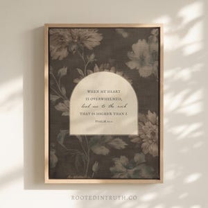 May include: A framed wall art print featuring a dark background with a floral pattern and a central cream-colored arch containing the text: WHEN MY HEART IS OVERWHELMED, lead me to the rock THAT IS HIGHER THAN I. PSALM 61:2.