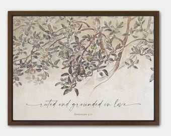 Puede incluir: Un cuadro decorativo enmarcado con una ilustración en acuarela de un manzano con hojas verdes y pequeñas manzanas rojas sobre un fondo beige. El texto "rooted and grounded in love" y "Ephesians 3:17" está impreso en letra cursiva negra.
