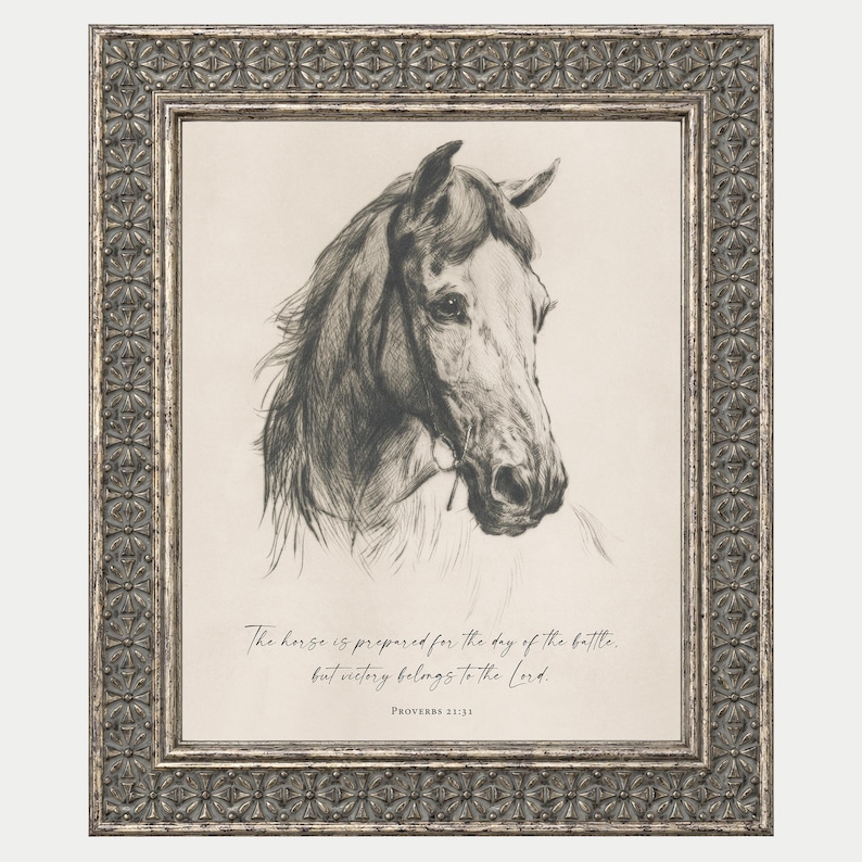 May include: A framed wall art piece featuring a charcoal-style sketch of a horse head. Below the horse, the text reads: The horse is prepared for the day of the battle, but victory belongs to the Lord. Proverbs 21:31. The frame has a metallic finish.