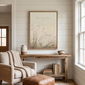 May include: A framed wall art print featuring a beige background with a botanical illustration of dried wildflowers and the text Peace be with you John 20:21 in a thin black script font, enclosed in a light-colored wooden frame.