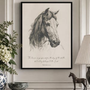 May include: A framed wall art print featuring a detailed charcoal-style sketch of a horse head facing right. Below the illustration, the text reads: The horse is prepared for the day of the battle, but victory belongs to the Lord. Proverbs 21:31.