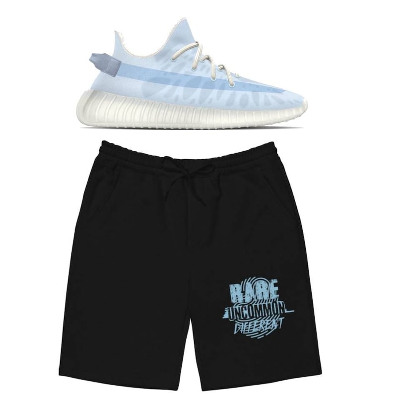 Puede incluir: Un par de pantalones cortos deportivos negros con un estampado gr&aacute;fico azul que dice "RARE UNCOMMON DIFFERENT". Los pantalones cortos se combinan con una zapatilla deportiva azul claro y blanca.