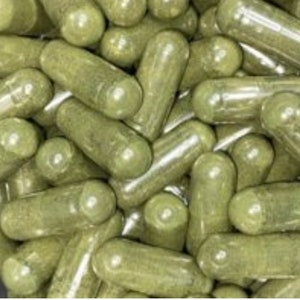 May include: A large group of green capsules, likely herbal supplements, are piled together.