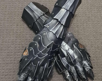 May include: Pair of black and silver gauntlets, featuring articulated finger and wrist armor. The gauntlets have a detailed, layered design with rivets and a metallic finish, suggesting a medieval or fantasy theme.
