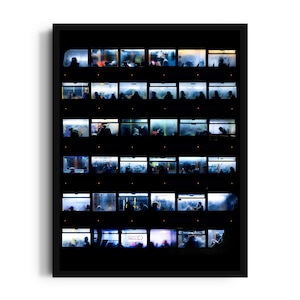 May include: A framed art print showing a grid of rectangular windows, each with a scene of silhouetted figures and colourful lighting. The overall composition is dark with bright highlights.