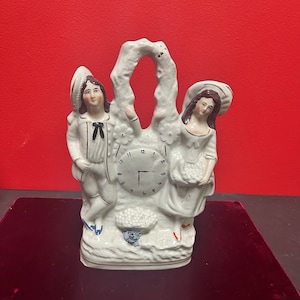 10 inch tall antique Staffordshire couple, holding a clock statue - great antique condition see photos