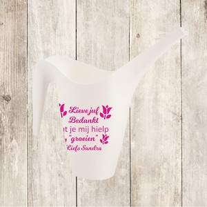 Op de afbeelding: Witte gieter met een roze opschrift dat luidt "Lieve juf Bedankt dat je mij hielp "groeien" Liefs Sandra" en roze tulpenillustraties.