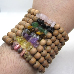 Peut inclure: Un ensemble de bracelets en perles de bois avec différentes perles de pierres précieuses, dont des perles roses, vertes, noires, jaunes et violettes.