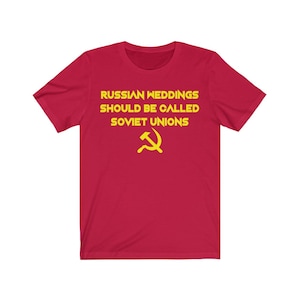 Peut inclure: T-shirt rouge avec l'inscription jaune « RUSSIAN WEDDINGS SHOULD BE CALLED SOVIET UNIONS » et un symbole de la faucille et du marteau jaune. Le t-shirt est de style col rond.
