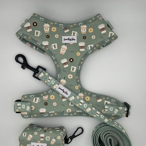 May include: A green dog harness, leash, and poop bag holder with a coffee cup and donut pattern. The harness and leash have the text "Love Pug Shop" on them. The poop bag holder has the text "Love Pug Shop" on it.
