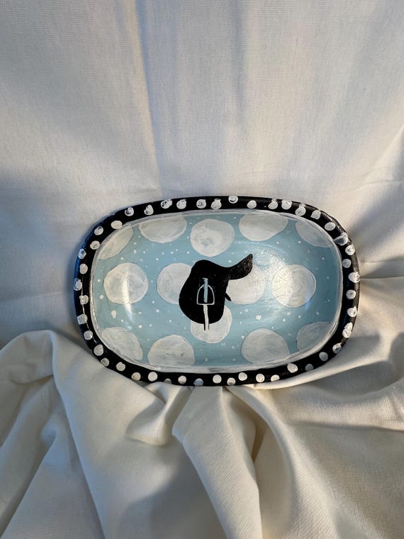 An  equestrian-themed bowl, repurposed from an antique silver vessel, boasting an elegant upstyled design featuring  an English saddle motif