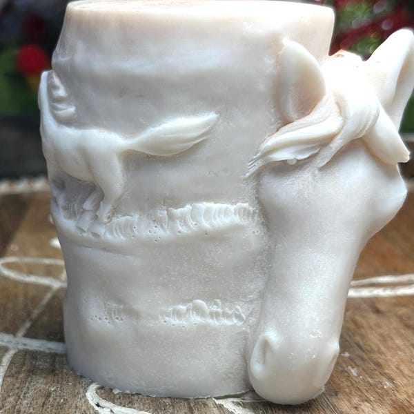 Deze kaars met paardenthema en rennende paarden heeft een zachte crèmekleur, versterkt door gouden krullen met bramen/vanille-aroma.