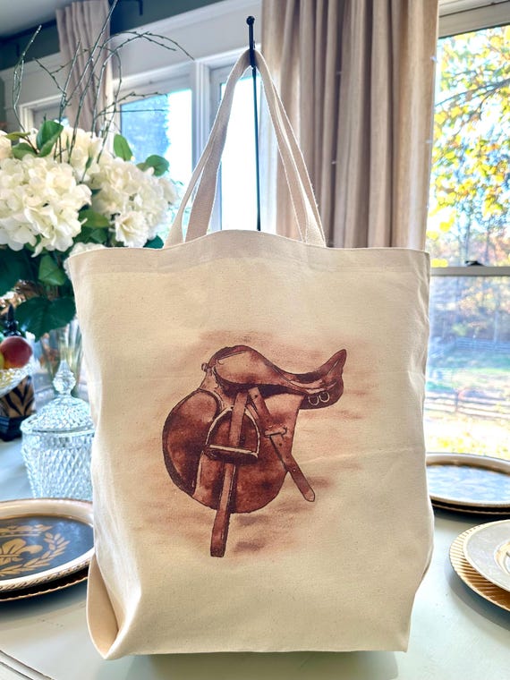 Experience the ultimate blend of style and practicality with our Three Pocket Canvas Tote Bag. Its streamlined design, featuring a Saddle.