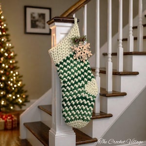 May include: A handmade Christmas stocking in cream and green chevron pattern, adorned with a wooden snowflake and sprigs of berries. The stocking is hanging on a white stair post, with a Christmas tree in the background.