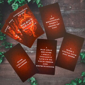 Puede incluir: Cinco cartas de or&aacute;culo con fondos rojos y naranjas y texto blanco. Las cartas presentan frases como "Coraz&oacute;n silencioso", "Me pongo emocional cuando pienso en ti", "Hu&iacute; porque sent&iacute; que no pod&iacute;a satisfacer tus necesidades y expectativas", "Gafas de color rosa" y "Ojal&aacute; pudiera darte m&aacute;s".