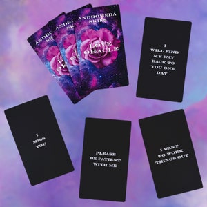 Puede incluir: Un juego de cartas negras con texto blanco. Las cartas presentan frases como "Te echo de menos", "Por favor, ten paciencia conmigo" y "Quiero arreglar las cosas". Tambi&eacute;n hay tres cartas con un fondo de galaxia y una flor rosa con el texto "Andromeda Skirts Love Oracle".