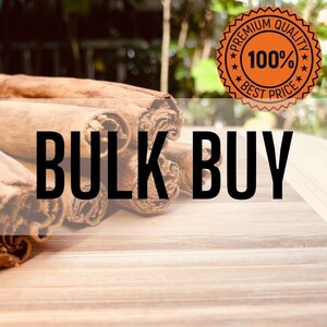 Könnte beinhalten: Nahaufnahme eines Stapels Zimtstangen auf einer Holzoberfläche. Die Stangen sind braun und haben eine raue Textur. Ein Aufkleber mit dem Text "Premium Quality 100% Best Price" ist im Hintergrund sichtbar. Der Text "Bulk Buy" ist über das Bild gelegt.