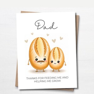 May include: A white greeting card featuring a cartoon illustration of two bread loaves with faces. The larger loaf has a mustache and the smaller one has eyelashes. Text reads "Dad" and "THANKS FOR FEEDING ME AND HELPING ME GROW" with small hearts.