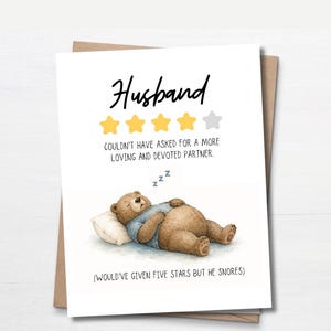 May include: A card with the word "Husband" in black script. The card features a sleeping bear illustration, rating stars, and the text "COULDN'T HAVE ASKED FOR A MORE LOVING AND DEVOTED PARTNER."