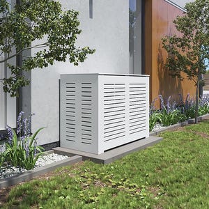 May include: White outdoor air conditioning unit with a slatted cover, sitting on a concrete base in front of a house. The unit is surrounded by landscaping with green grass and purple flowers.