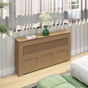 May include: A brown wooden radiator cover with a slatted design and a shelf on top. The cover has three panels and is sitting on a wooden floor.