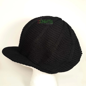 May include: Black knitted beanie with a flat brim. The beanie has a cable knit pattern and a small logo that says "ZIONGATES DULICHA SHOP".