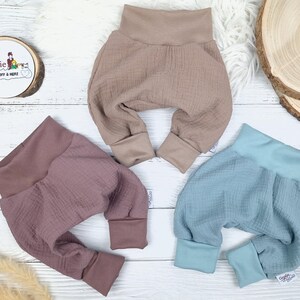 Pu&ograve; includere: Tre paia di pantaloni per neonati in diversi colori: marrone chiaro, rosa polvere e blu chiaro. I pantaloni sono realizzati in un tessuto morbido e testurizzato e hanno una vestibilit&agrave; comoda e ampia.