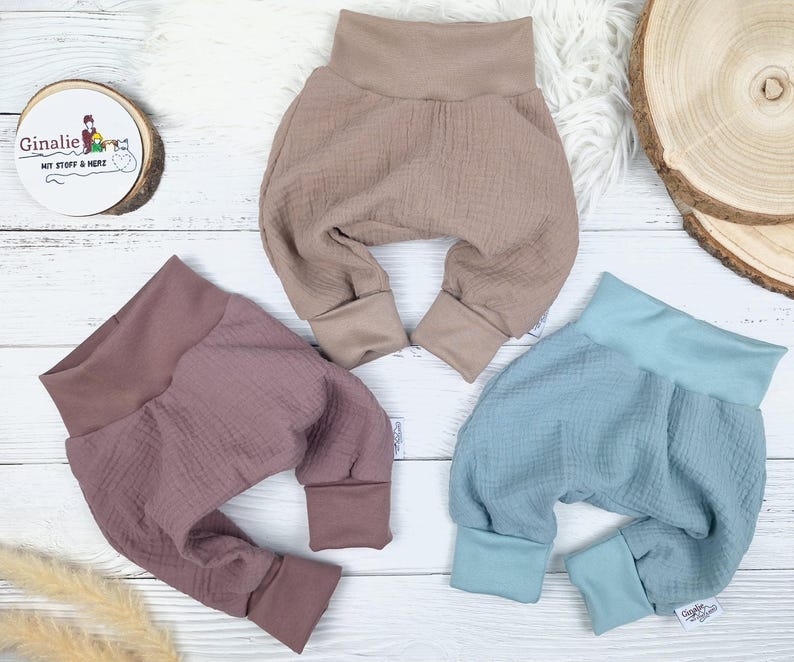 Pu&ograve; includere: Tre paia di pantaloni per neonati in diversi colori: marrone chiaro, rosa polvere e blu chiaro. I pantaloni sono realizzati in un tessuto morbido e testurizzato e hanno una vestibilit&agrave; comoda e ampia.