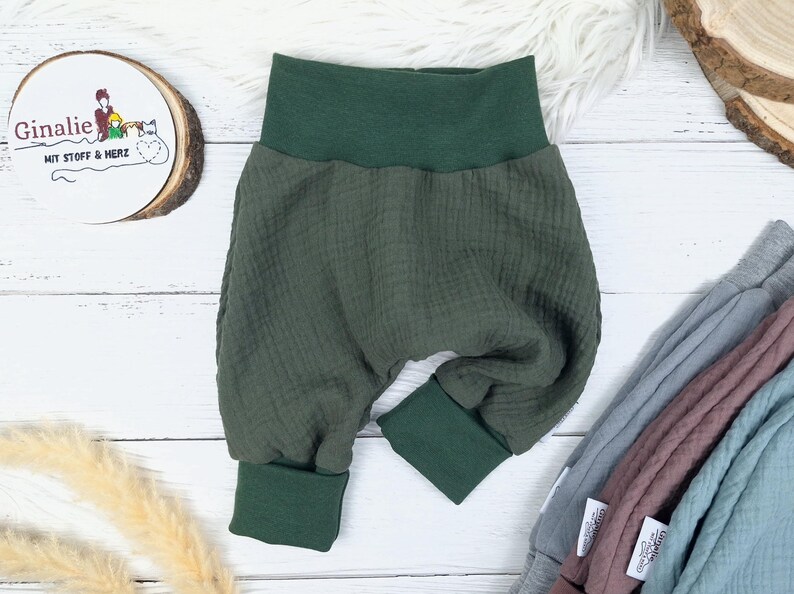 Pu&ograve; includere: Pantaloni per neonati di colore verde, in tessuto strutturato con elastico in vita. I pantaloni hanno le gambe con risvolto.