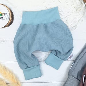 Pu&ograve; includere: Pantaloni per neonati di colore azzurro chiaro con vita elastica e gambe con polsini. I pantaloni sono realizzati in un tessuto morbido e testurizzato.