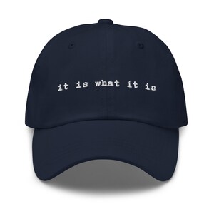 May include: A navy blue baseball cap with the text "it is what it is" embroidered in white on the front.