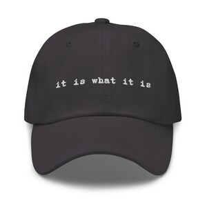 May include: A black dad hat with the text "it is what it is" embroidered in white on the front.
