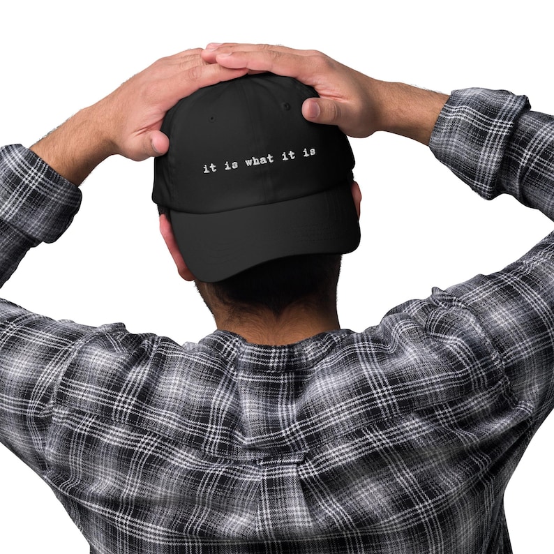 May include: A black baseball cap with white text that reads "it is what it is".
