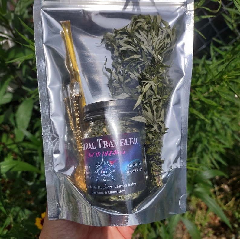 Puede incluir: Una bolsa de pl&aacute;stico transparente que contiene un frasco de vidrio lleno de hierbas secas y un palo de madera. El frasco tiene una etiqueta negra con el texto "Astral Traveler Lucid Dreams" y "Ideal para la meditaci&oacute;n". La etiqueta tambi&eacute;n enumera los ingredientes: Ajenjo, Melisa, Damiana & Lavanda.
