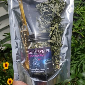 Puede incluir: Una bolsa de pl&aacute;stico transparente que contiene un frasco de vidrio lleno de hierbas secas, una varita dorada y un peque&ntilde;o manojo de hierbas secas. El frasco tiene una etiqueta negra que dice "FIRAL TRAVELER LUCID DREAMS" y "Ideal para la meditaci&oacute;n". La etiqueta tambi&eacute;n enumera los ingredientes: "Ajenjo, melisa, damiana y lavanda".